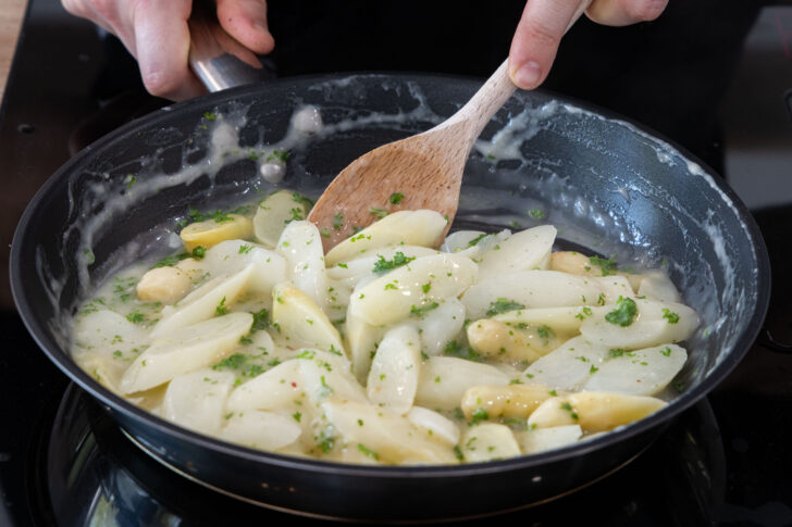 Spargelragout mit Kräutern mischen
