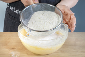 Mehl, Puddingpulver, Backpulver und Salz zum Teig sieben