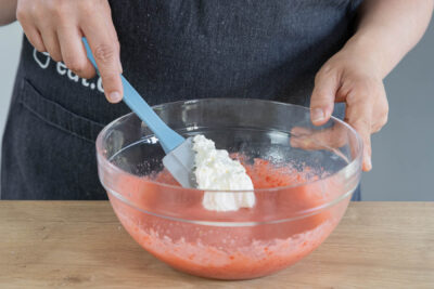 Für die Creme der Erdbeer-Sahne-Torte die Sahne unterheben