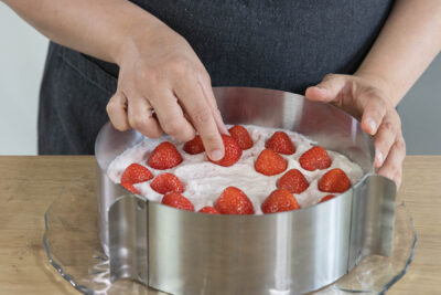 Erdbeeren auf einer Schicht Sahne verteilen