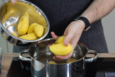 Kartoffeln in einen Topf geben