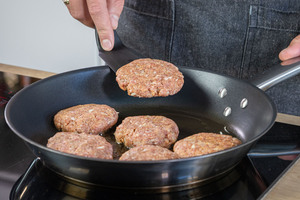 Frikadellen mit Paniermehl in die Pfanne geben