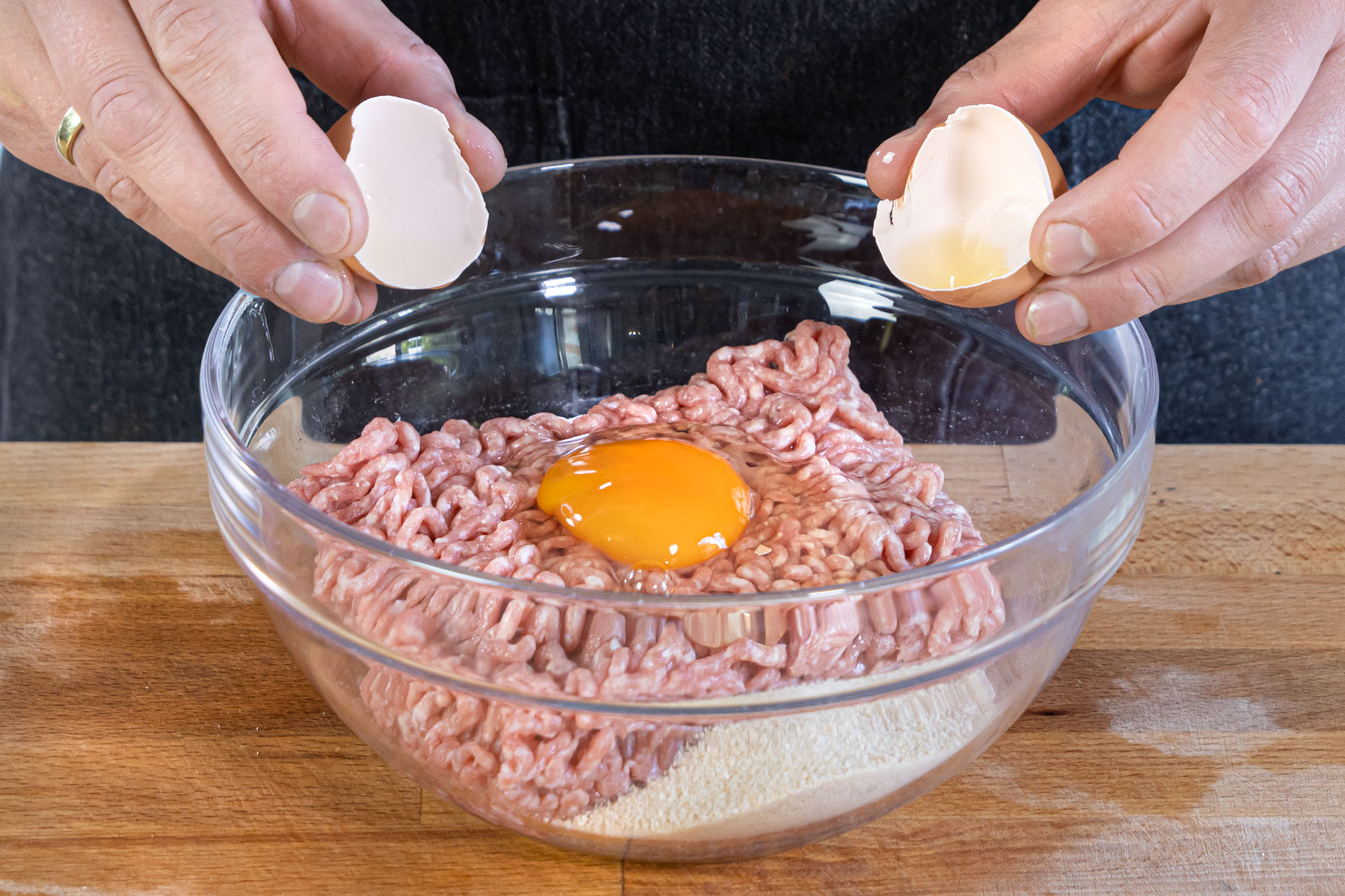 Ei und Paniermehl zum Hackfleisch geben
