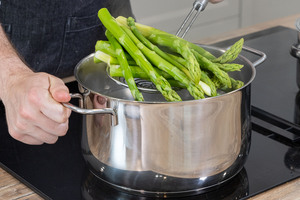 grünen Spargel aus dem Topf nehmen