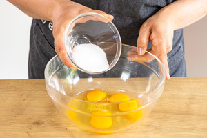 Zucker und Salz zu den Eiern geben