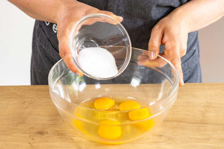 Zucker und Salz zu den Eiern geben