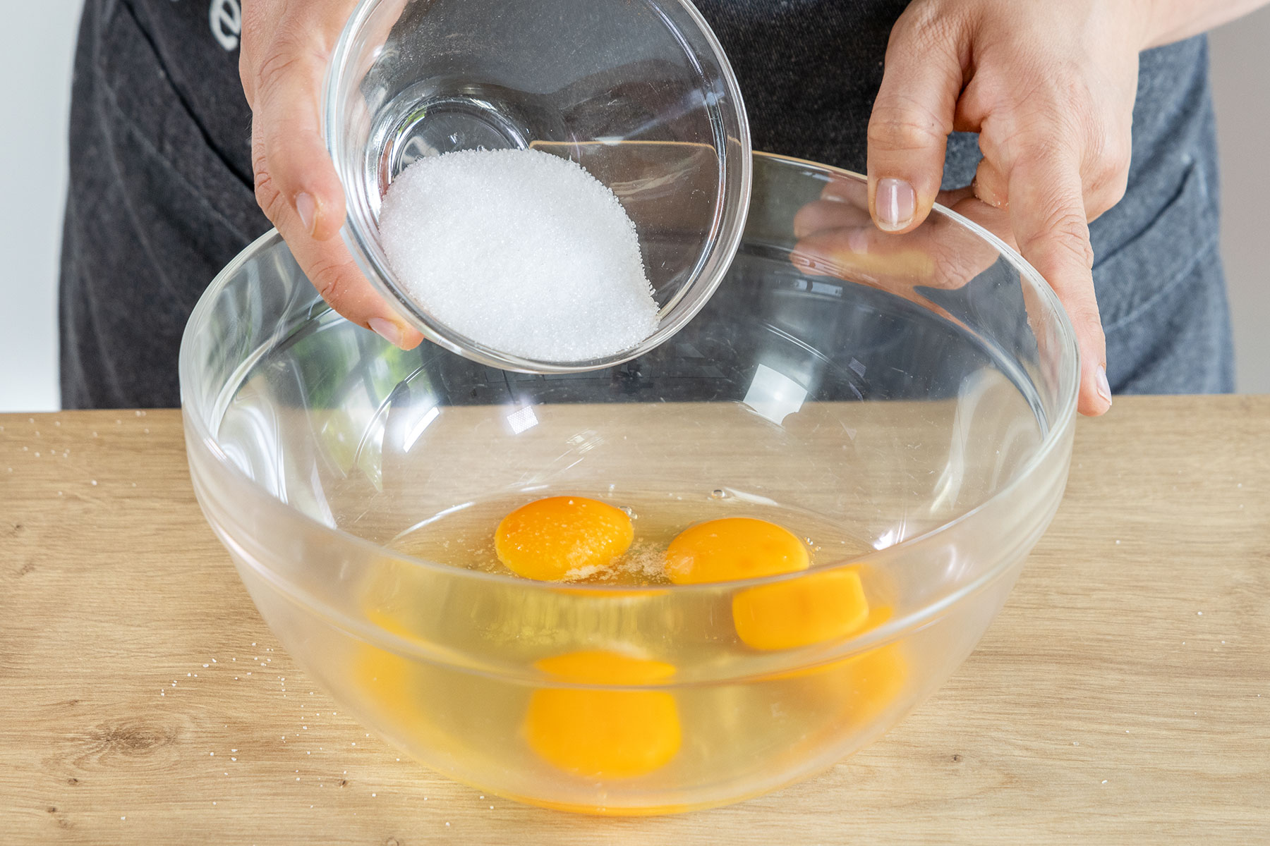 Zucker und Salz zu den Eiern geben
