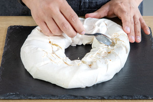 Klassische Pavlova mit einem Löfel aufbrechen
