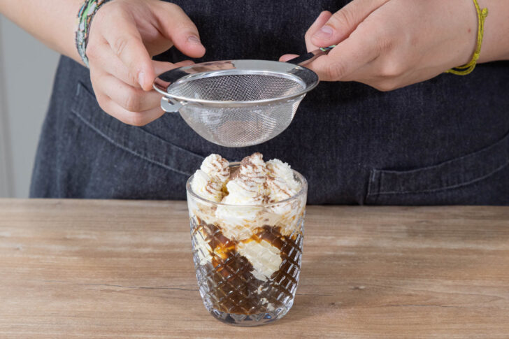 Klassischen Eiskaffee mit Kakaopulver dekorieren