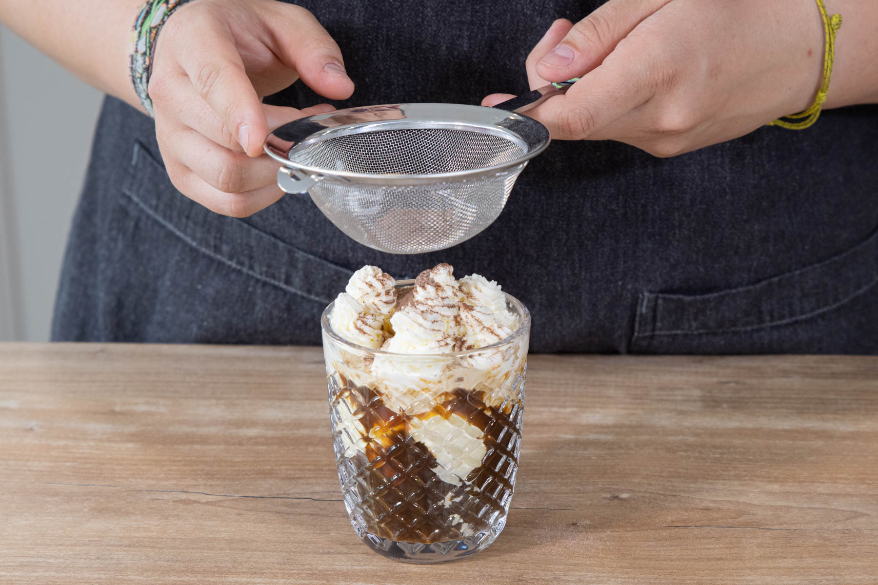 Klassischen Eiskaffee mit Kakaopulver dekorieren