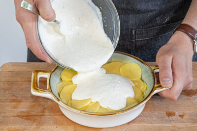 Gratinmasse über die Kartoffeln geben