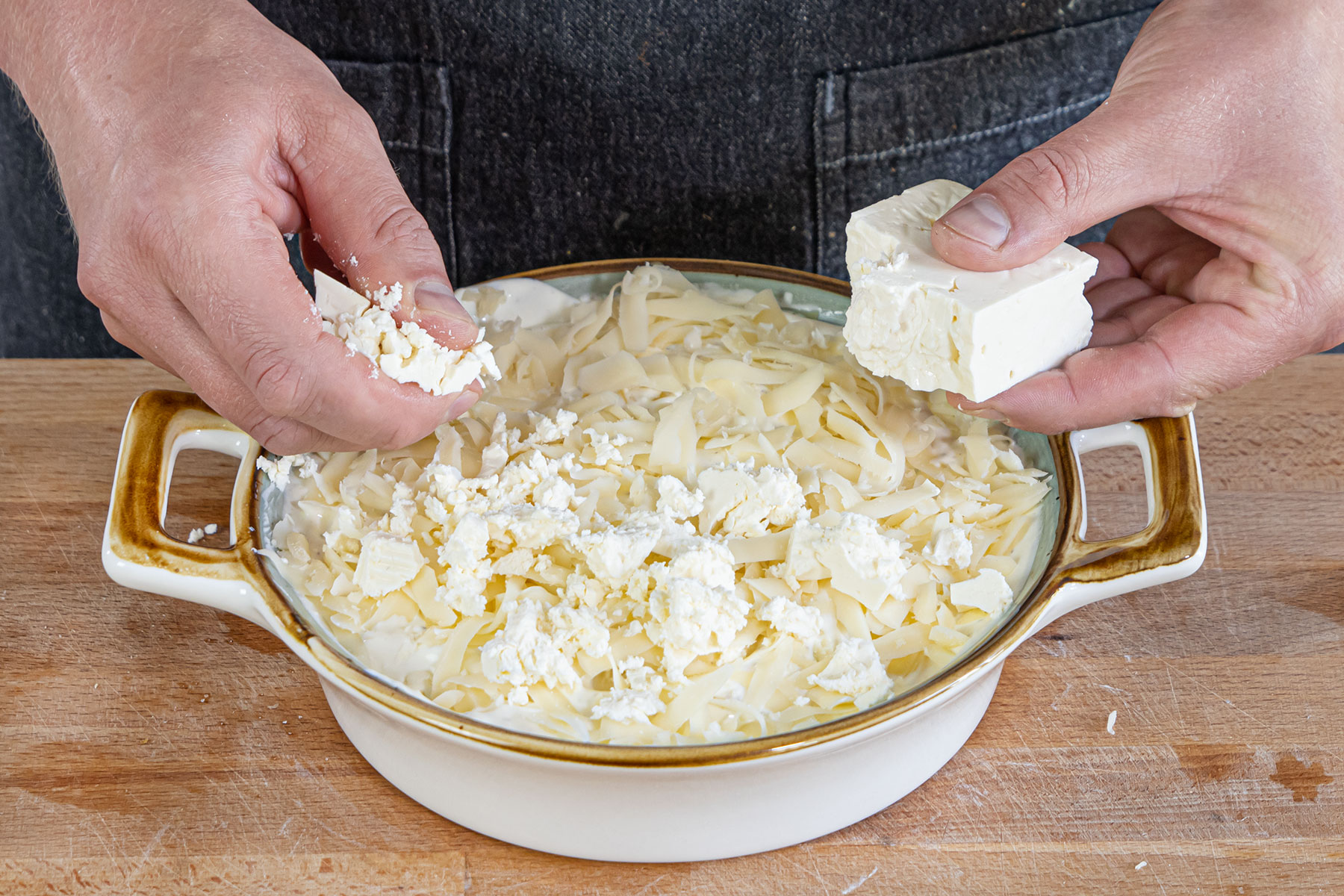 kretanische Kartoffeln mit Feta und Edamer bestreuen