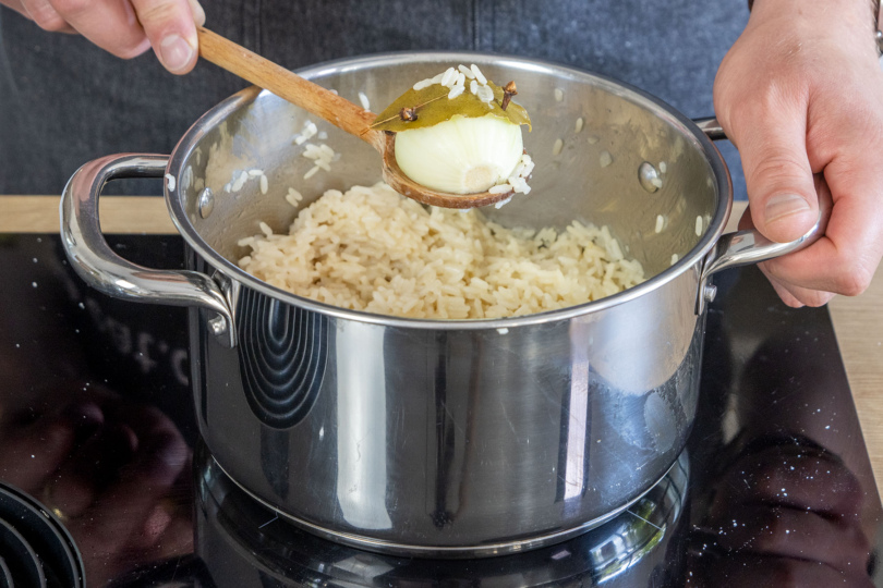 gespickte Zwiebel aus dem Pilaw Reis herausnehmen