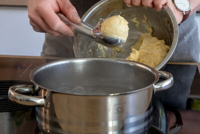 Topfenknödel ins Wasser geben