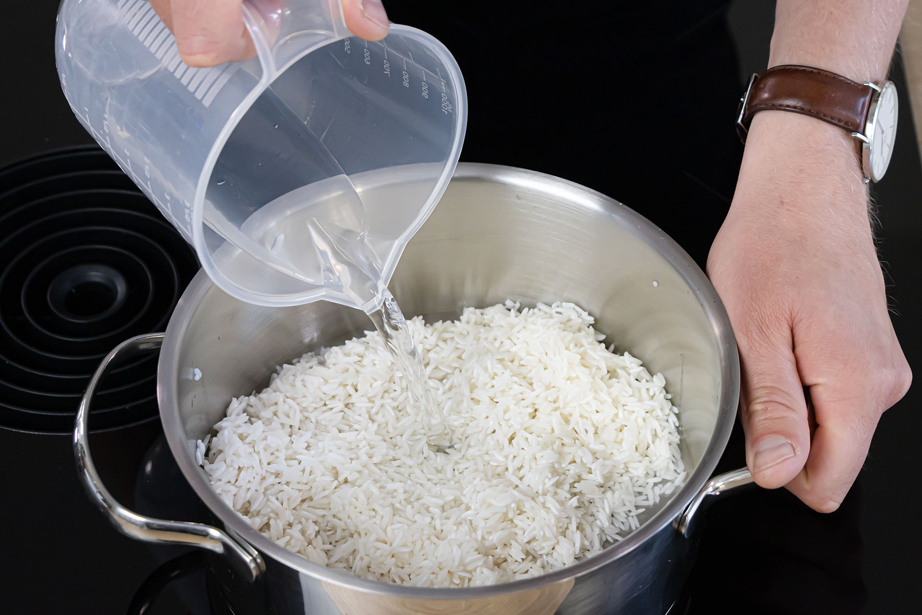 Reis mit Wasser und Salz in einen Topf geben