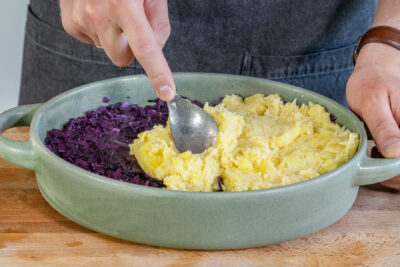 Kartoffelbrei auf den Rotkohl verteilen