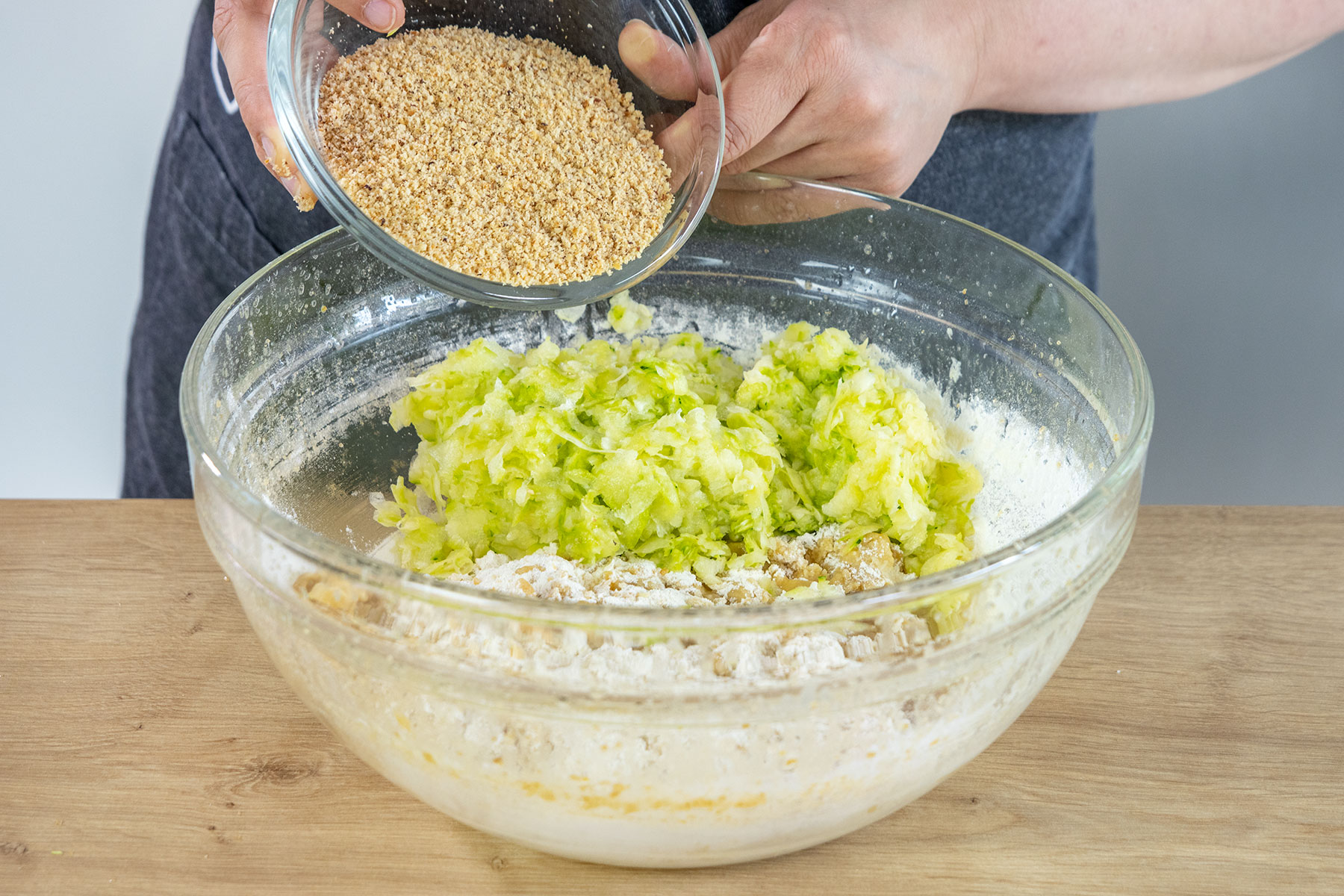geriebene Zucchini und gemahlene Haselnüsse dazugeben