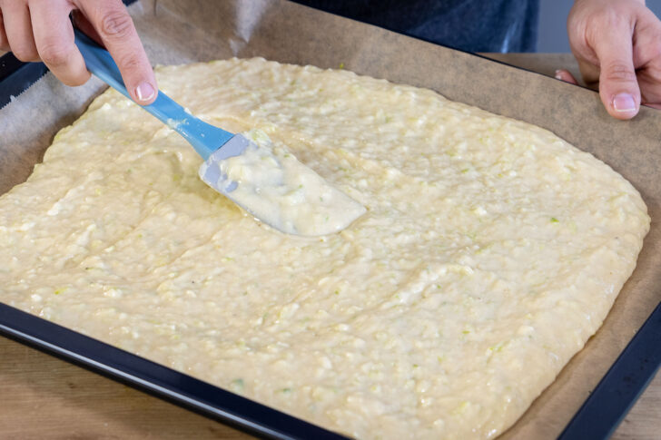 Zucchinikuchenteig auf dem Backblech verstreichen