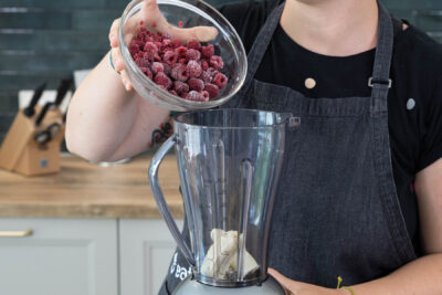 Gefrorene Himbeeren in den Mixer geben