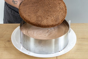 zweiten Boden auf die Cremeschicht der Schoko-Sahne-Torte legen