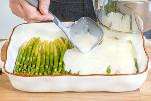 Sauce auf dem grünen Spargel verteilen