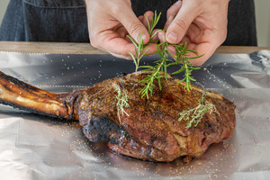 Rosmarin und Thymian zweige auf das Fleisch legen