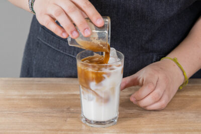 Für den veganen Eiskaffee den Espresso dazugießen