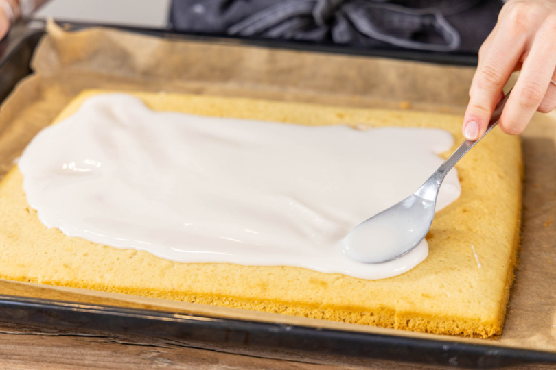 Guss auf den veganen Zitronenkuchen streichen