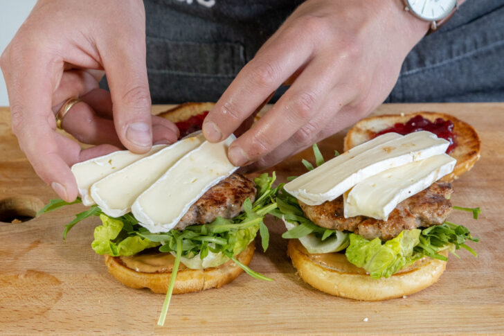 Rucola, Wildschwein Burger Patty und Camembert darauflegen