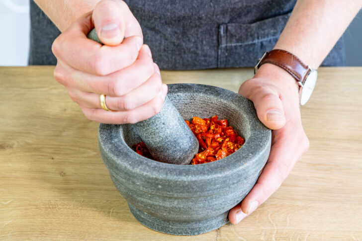 getrocknete Chilis zu Flocken mörsern
