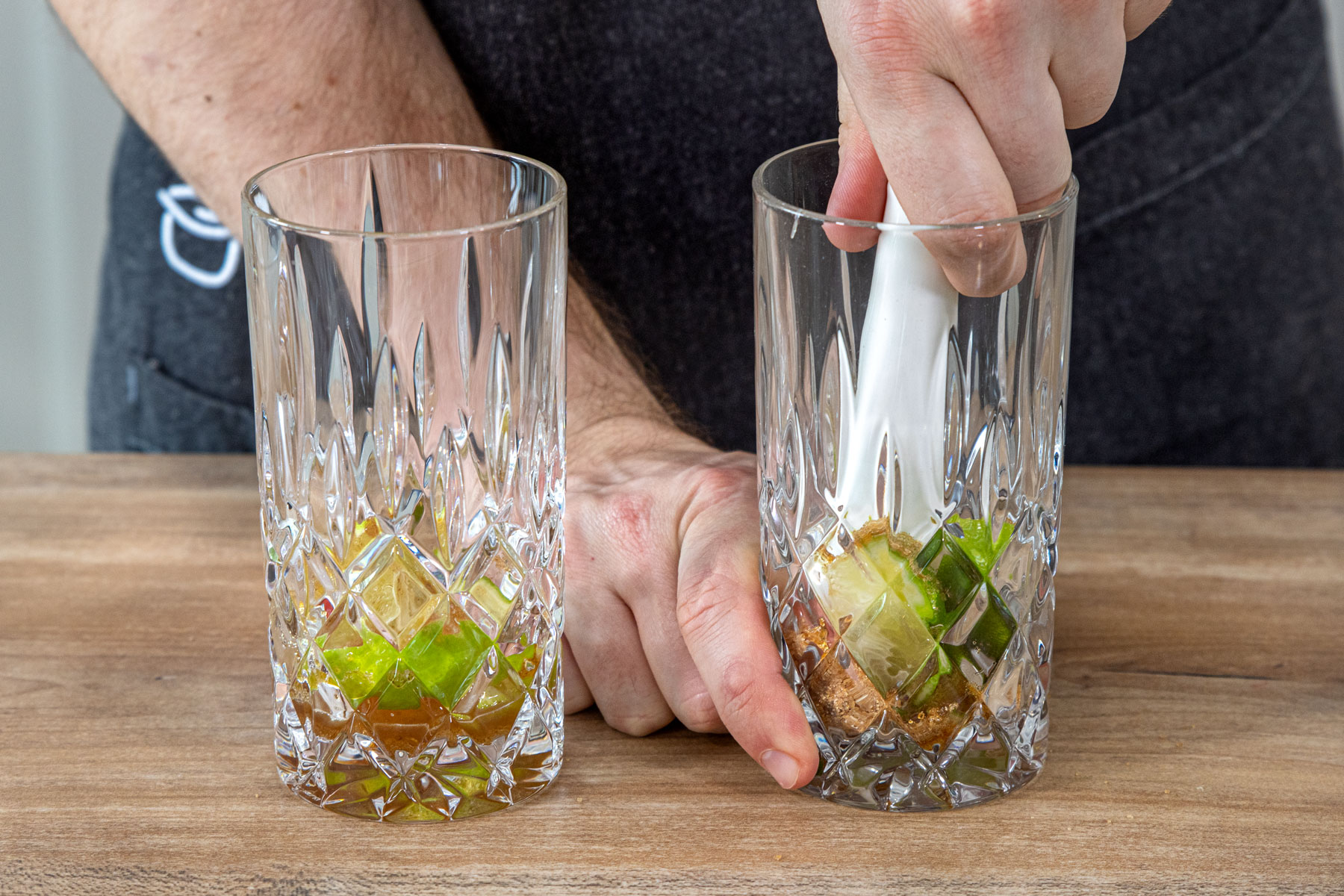 Limetten und Zucker mit dem Stößel zerdrücken