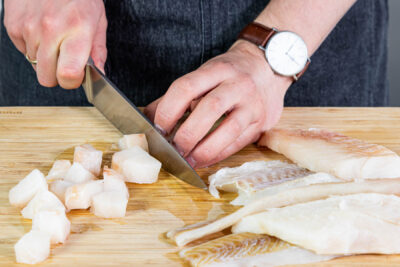 Fischfilet in Würfel schneiden