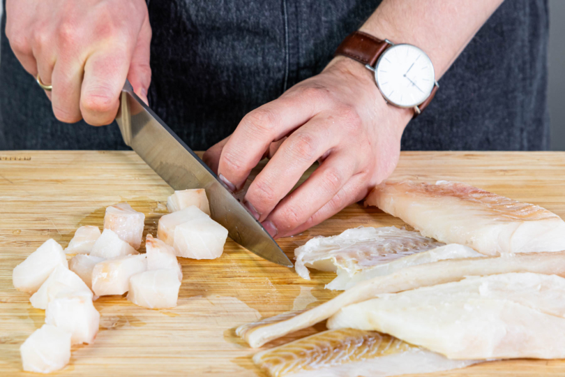 Fischfilet in Würfel schneiden