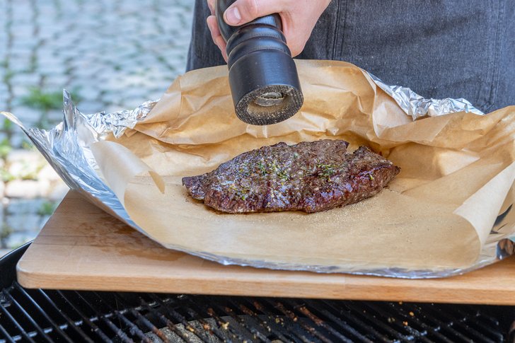 Das gegrillte Steak würzen