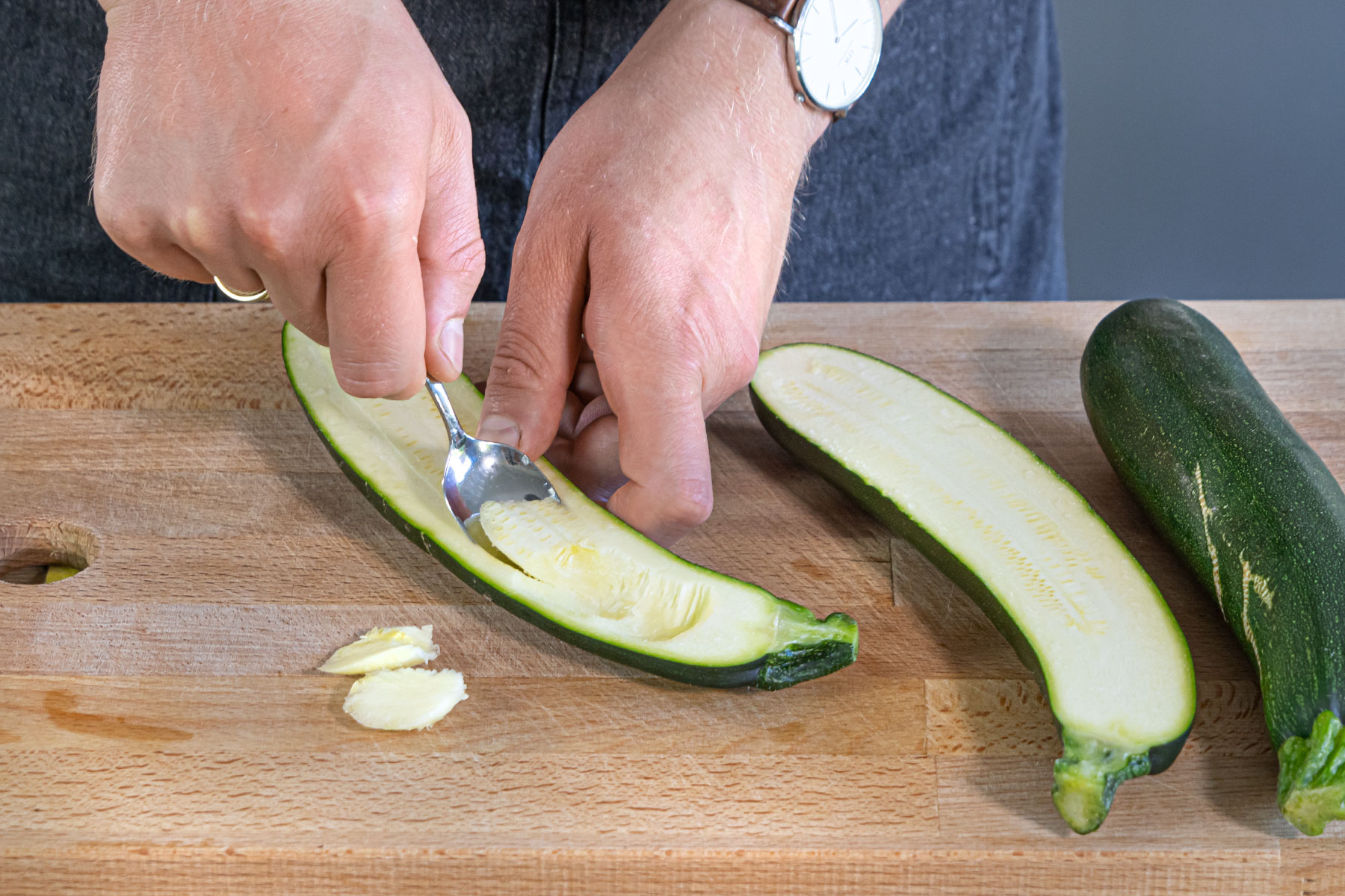 Zucchini halbieren und Kerngehäuse mit Löffel entfernen