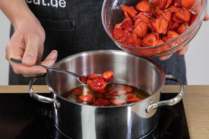 Erdbeeren in einen Topf geben