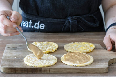 Erdnussbutter auf Reiswaffel verstreichen