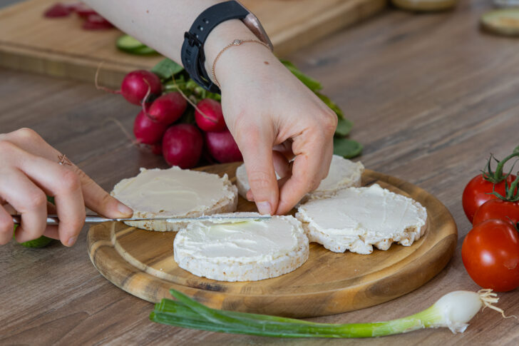 Frischkäse auf Reiswaffel verstreichen