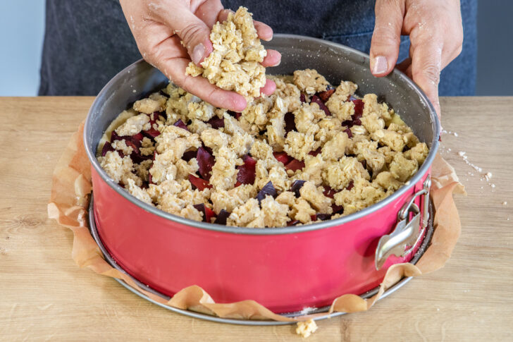 Streusel auf Pflaumenkuchen mit Mürbeteig krümeln