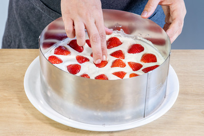 Erdbeeren in die helle Creme drücken