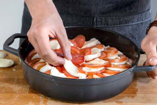 Tomate und Mozzarella auf dem Schnitzel verteilen