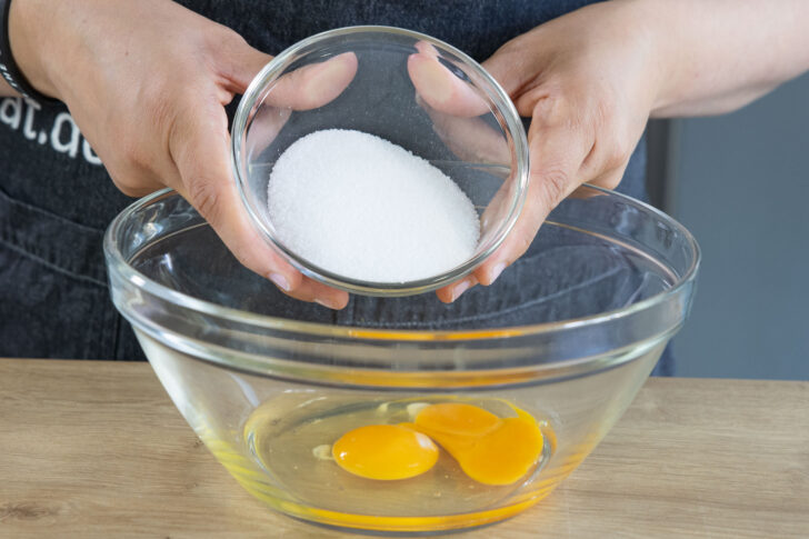 Eier und Zucker in Schüssel geben