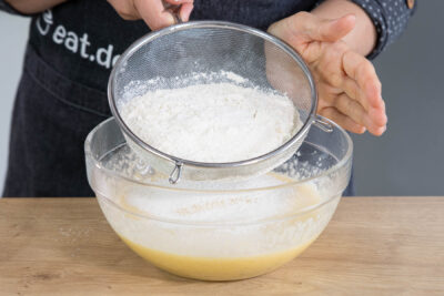 Mehl in den Waffelteig einsieben