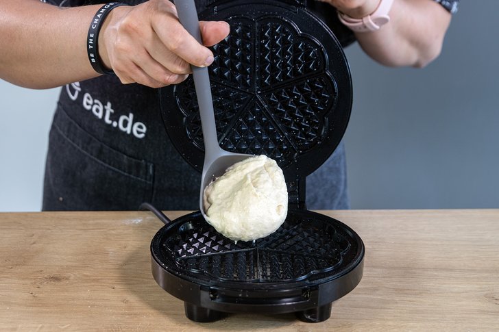 Waffelteig in Waffeleisen geben