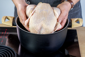 Suppenhuhn in einen Topf geben