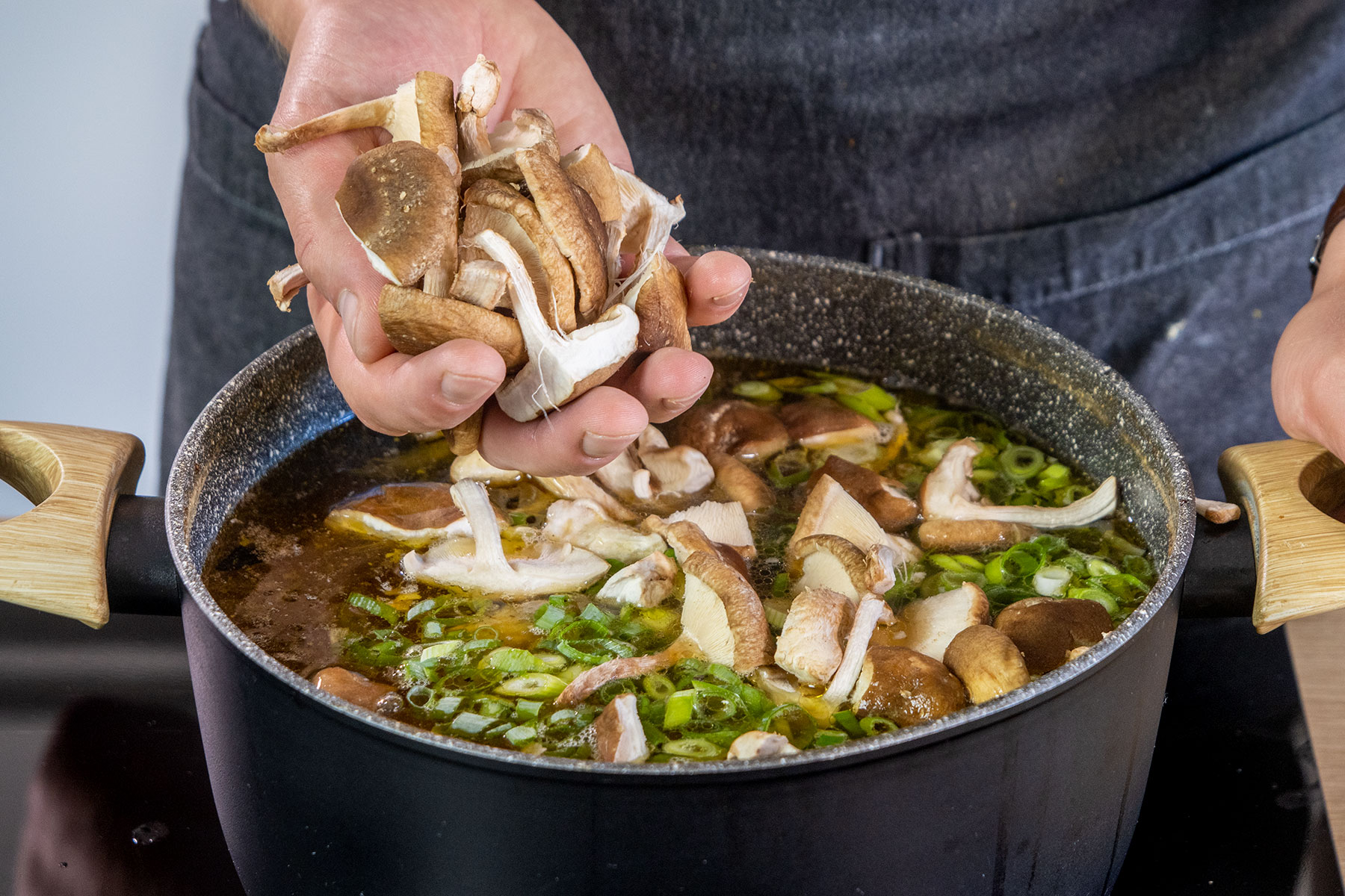 Shiitake Pilze zur asiatischen Hühnersuppe geben