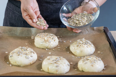 Brötchen mit Körnern bestreuen