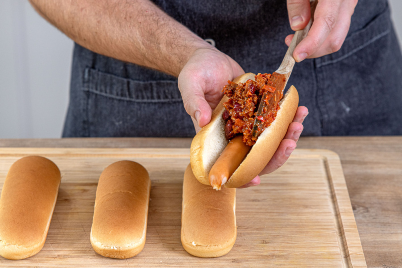 Chili im Hot Dog verteilen