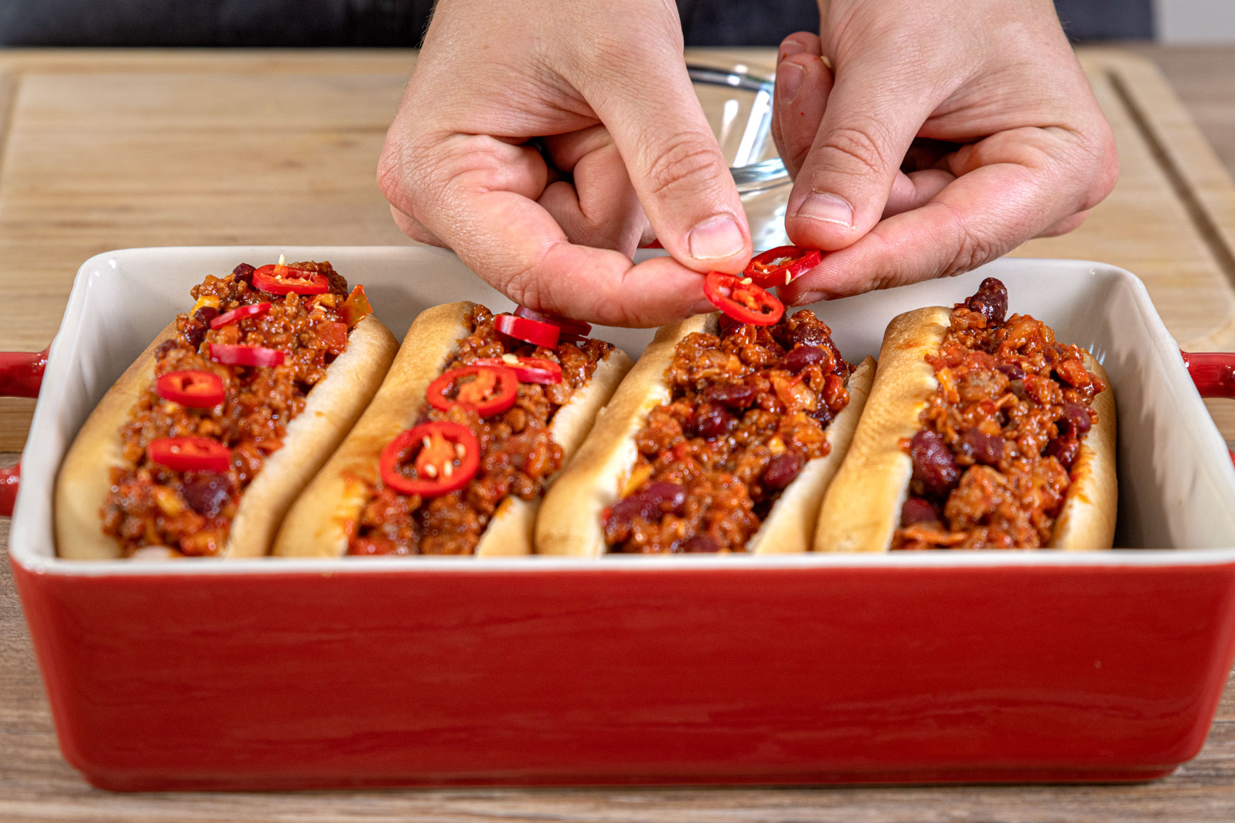 Chilis auf Hot Dog verteilen