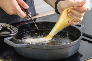 Churroteig in das Öl geben